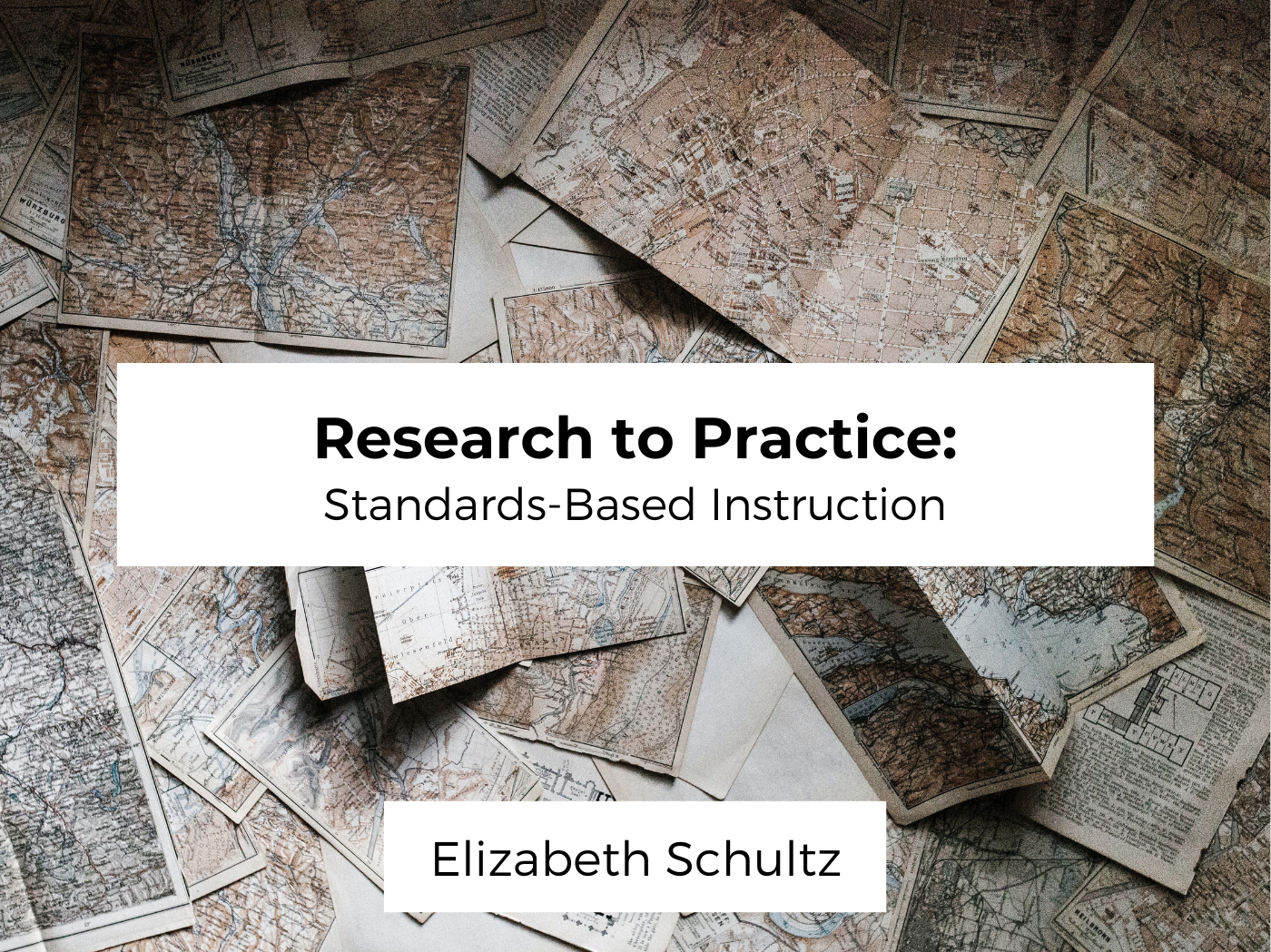 Image of folded unidentifiable maps on a table behind two white boxes that are centered. The first white box has the title of the post; Research to Practice: Standards-Based Instruction. The lower white box has the author name, Elizabeth Schultz.
